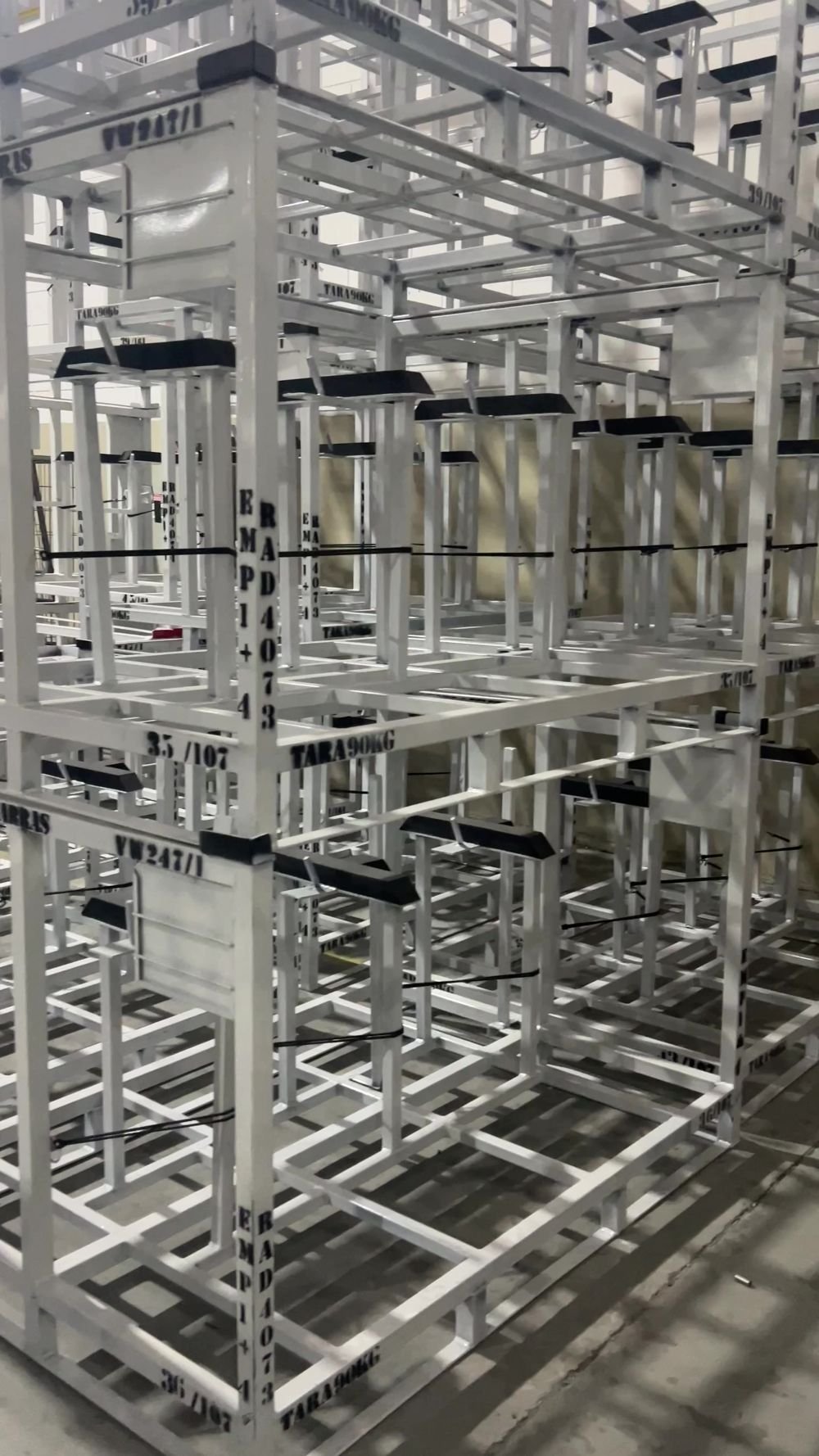 Racks industriais brancos empilhados para armazenagem de componentes